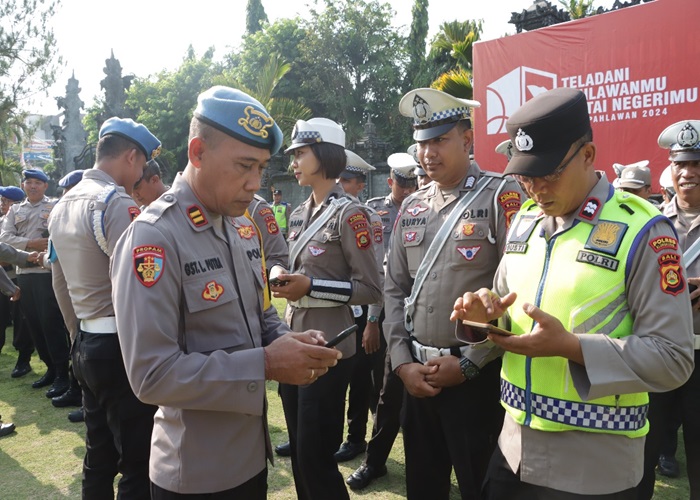 DIPERIKSA : Personel Polres Klungkung saat dicek HP oleh Propam.
