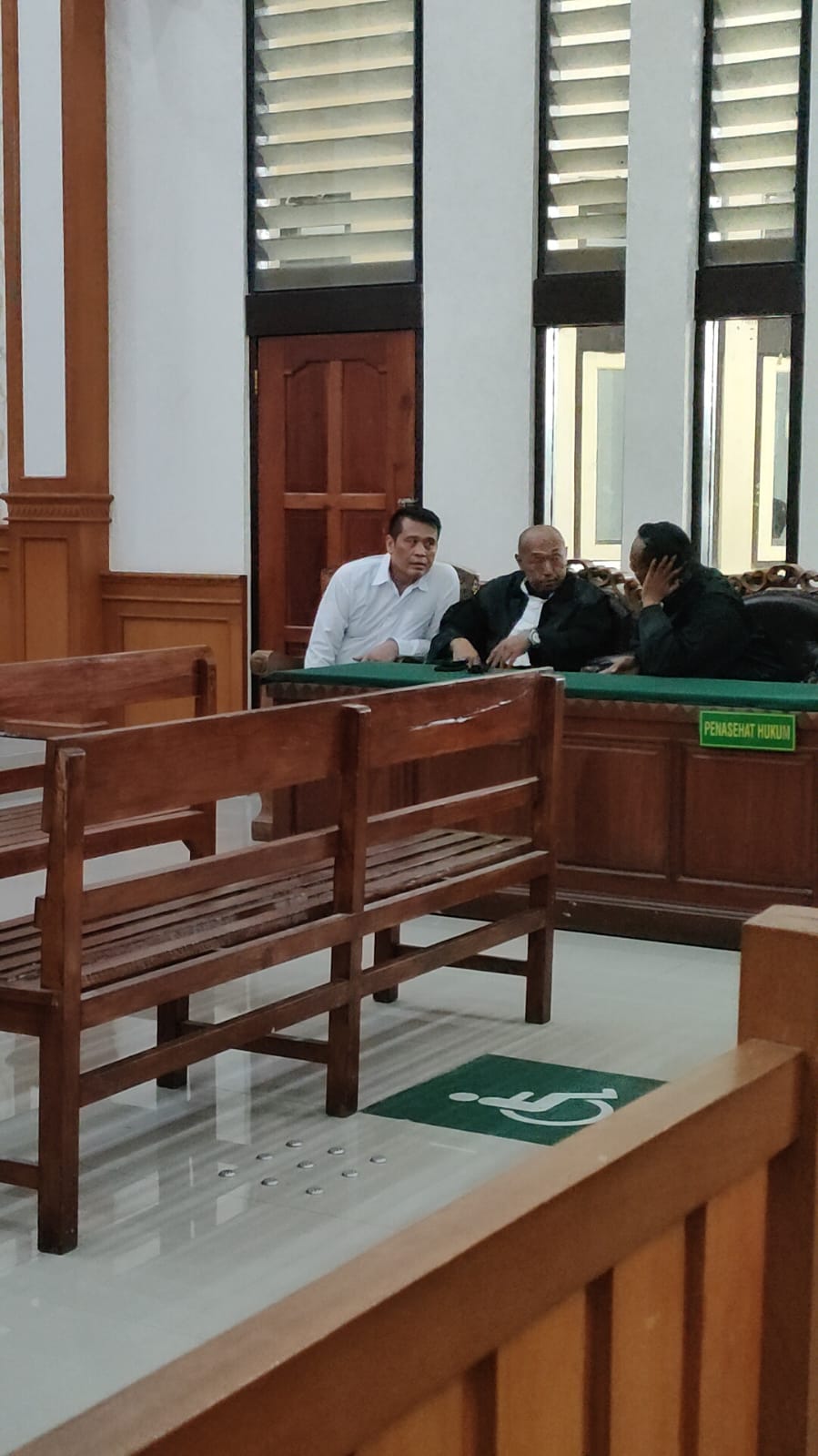 Terdakwa Sukojin (baju putih) berdiskusi dengan Penasihat Hukumnya setelah pembacaan tuntutan oleh JPU di PN Denpasar. (Bali Express/I Gede Paramasutha)