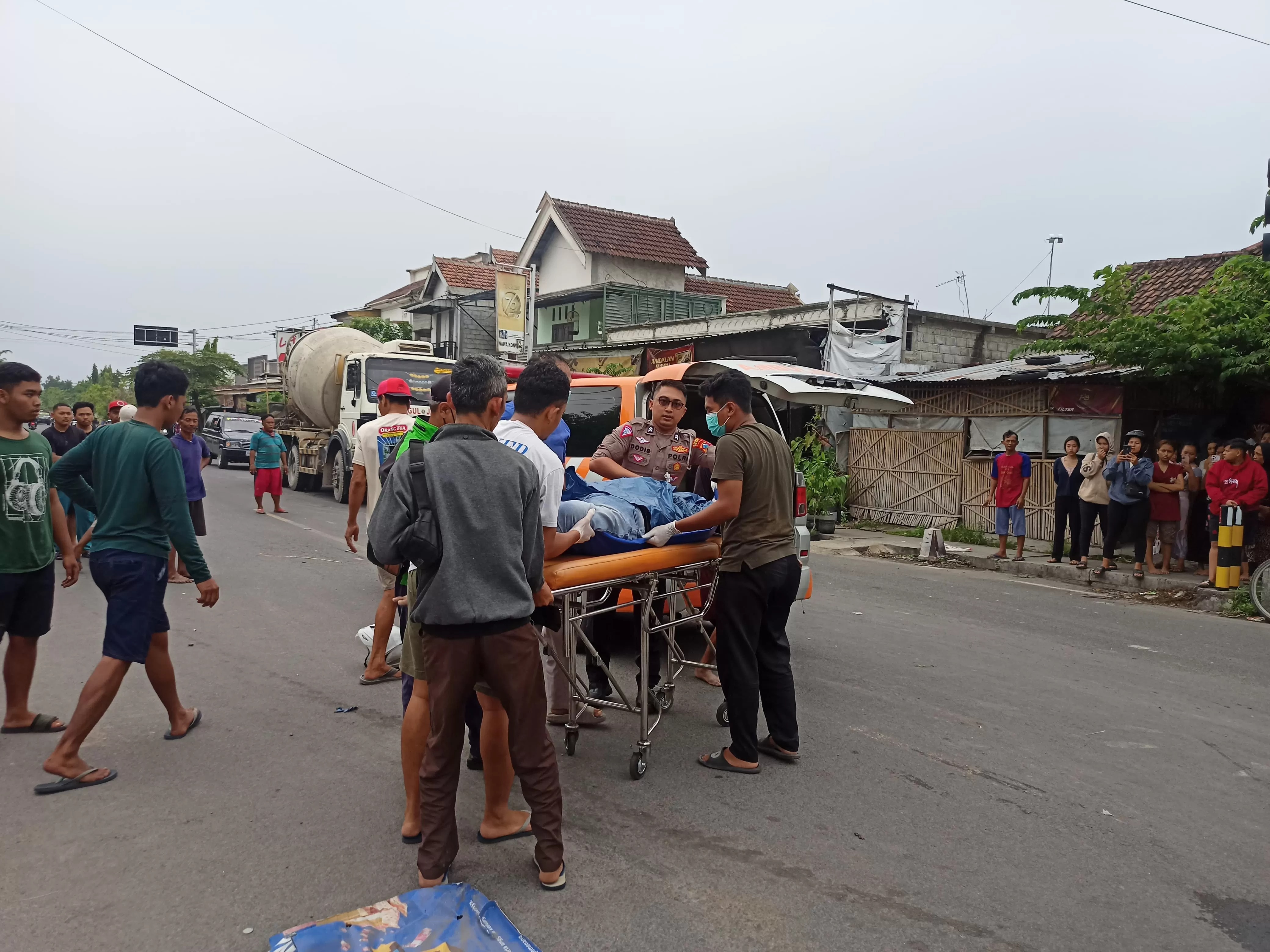 KECELAKAAN MAUT: Petugas kepolisian, tim medis, dan warga mengevakuasi pasangan suami istri yang jadi korban kecelakaan di Traffic Light Branggahan Ngadiluwih Kediri.