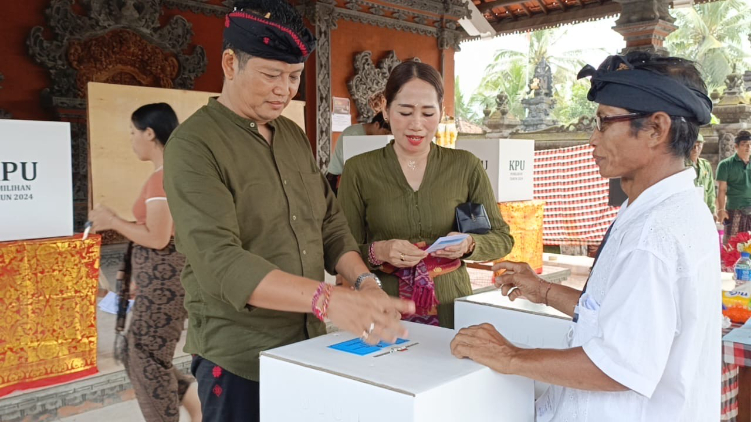 Calon Bupati Jembrana, nomor urut 2, I Made Kembang Hartawan menggunakan hak pilihnya di TPS 01, Desa Pangyangan, Kecamatan Pekutatan, Rabu (27/11/2024). Kembang hadir didampingi istri dan kedua anak