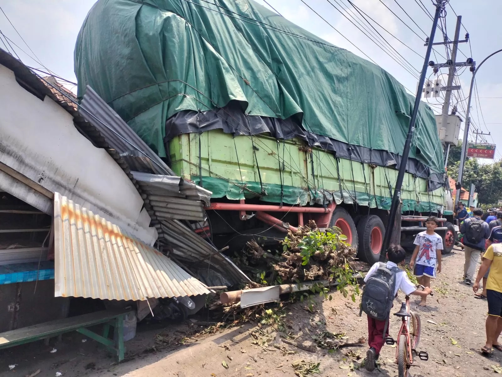 RINGSEK : Kondisi warung terlihat ringsek dan tiga sepeda motor ikut ringsek usai dihantam truk bermuatan mie instan yang diduga alami rem blong di Jalan Raya Kedamean, Gresik (Yudhi Radar Gresik )