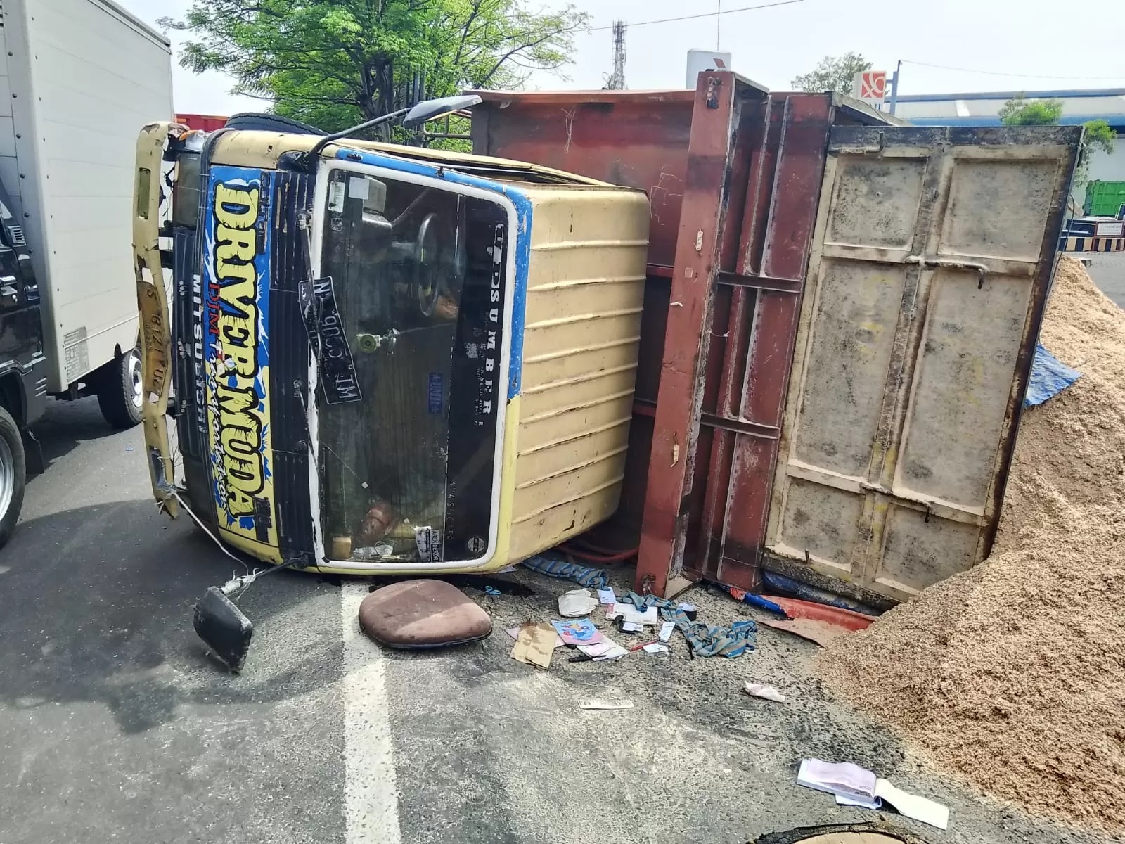 APES: Truk muat serbuk kayu terguling di Jalan Raya Taman, Rabu (4/12). (IST)