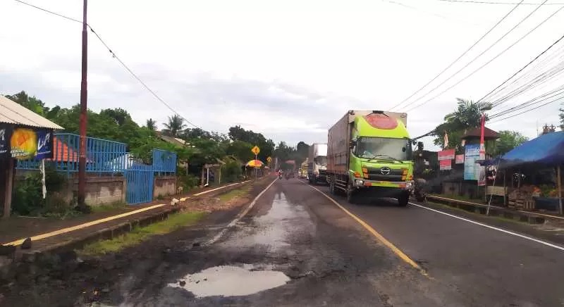BERBAHAYA : Jalan berlubang di Jalan Denpasar - Gilimanuk, wilayah Banjar Munduk Ranti, Desa Tukadaya, Kecamatan Melaya, Jembrana. (m.basir/radar bali)