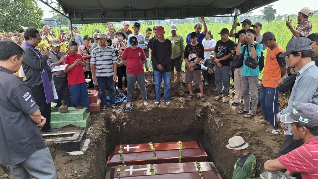 PENUH HARU: Satu keluarga korban pembunuhan di Ngancar Kediri dimakamkan di satu liang lahat. (ASAD MS/JPRK)