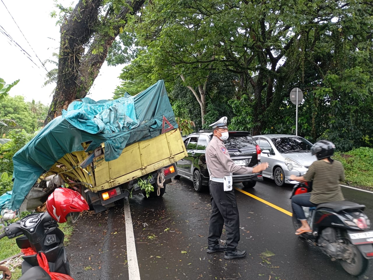 TABRAK POHON: Truk pengangkut jagung yang datang dari arah Gilimanuk mengalami kecelakaan di Banjar Dinas Jelijih Selemadeg Timur, Senin pagi (9/12).