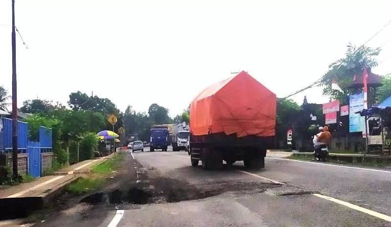 BAHAYA JALAN BERLUBANG : Kondisi jalan berlubang depan kantor Desa Tukadaya yang makan korban jiwa. (m.basir/radar bali)