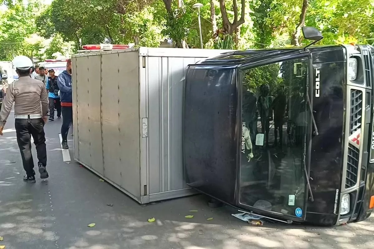 mobil box yang terguling di depan Taman Prestasi, Jalan Ketabang Kali, Surabaya, pada Kamis (19/12/) siang. (BPBD Kota Surabaya)