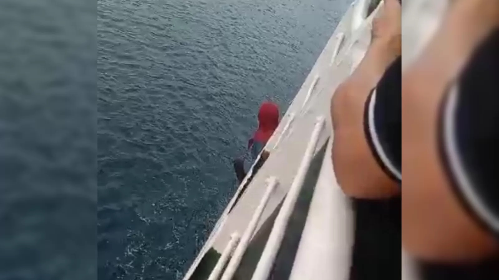 MELOMPAT: Momen Wayan Indriani melompat dari KMP Citra Mandala Sakti di perairan Selat Bali. (Repro)