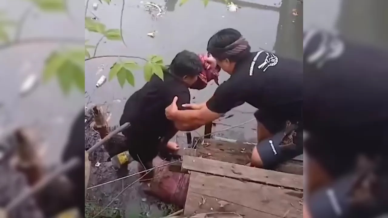 EVAKUASI: Warga mengevakuasi orok yang ditemukan mengambang di wilayah Pemelisan, Sesetan. (Repro Facebook Van Wira)