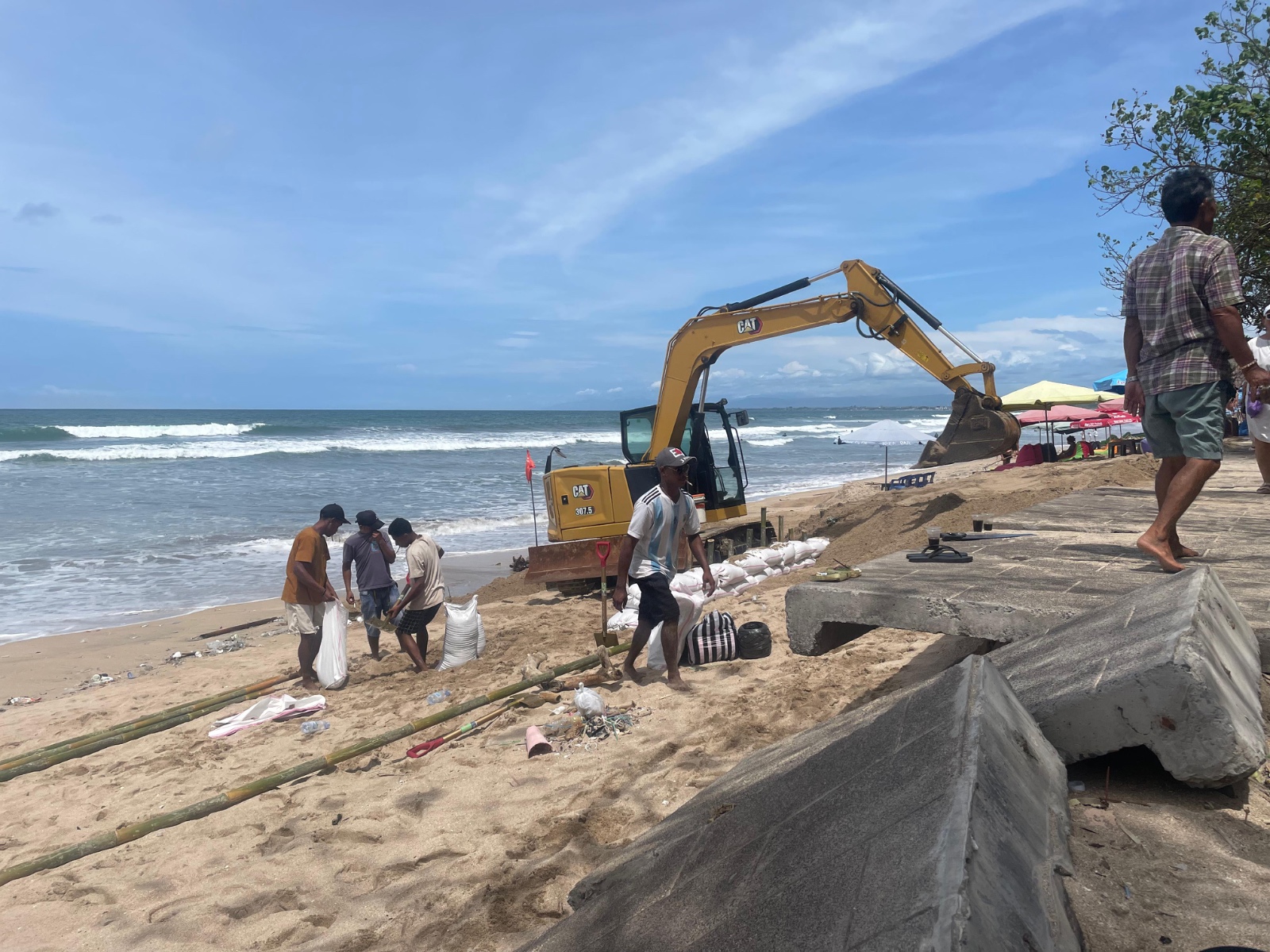 DIPERBAIKI: Tim Dinas PUPR Badung bersama para pedagang melakukan perbaikan pedestrian di Pantai Kuta, Minggu (19/1).