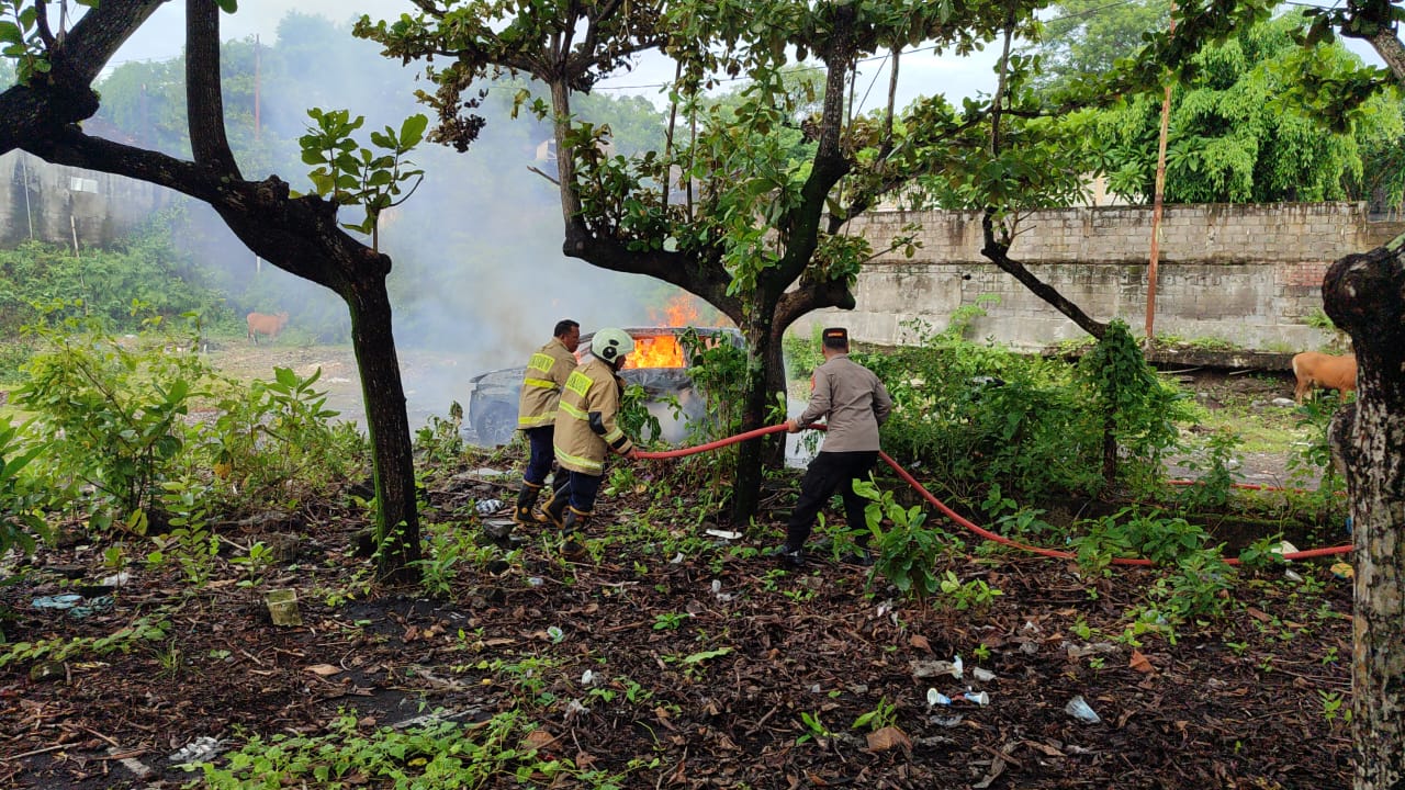 Kapolsek Kuta Selatan Kompol I Gusti Ngurah Yudistira saat membantu petugas Pemadam Kebakaran menangani mobil terbakar. (Bali Express/Istimewa)