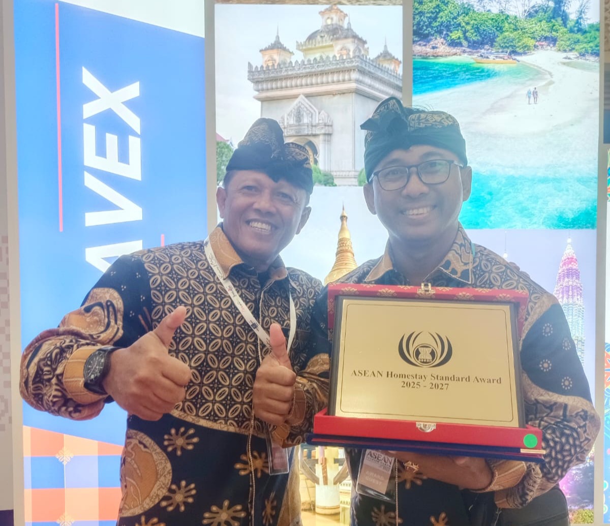 Perbekel Desa Sudaji, Made Ngurah Fajar Kurniawan (pegang plakat) bersama Ketua Pokdarwis Gede Suharsana saat menerima ATA 2025 di Johor, Malaysia