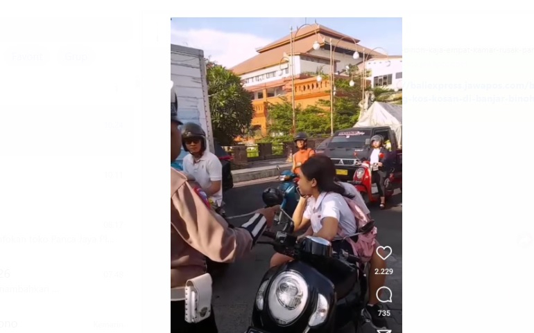 Seorang petugas kepolisian menegur pelajar SMP berkendara tanpa helm
