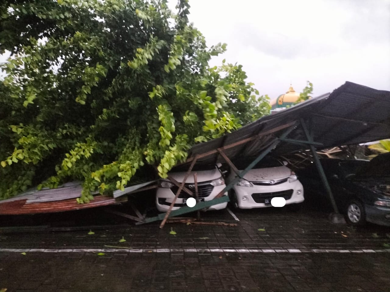 TIMPA: Empat mobil di garase Asrama TNI AD di Kuta tertimpa pohon tumbang. (Bali Express/Istimewa)