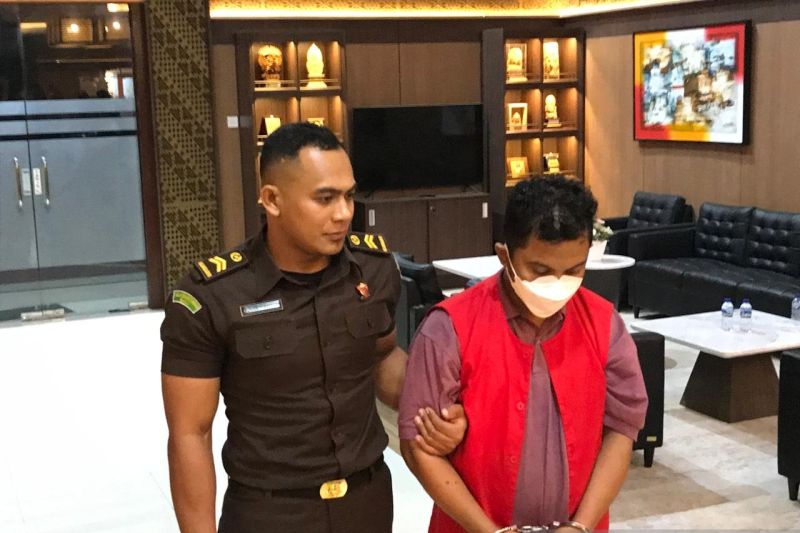 Petugas Kejati Bali menunjukkan I Wayan Depa Yogiana, terpidana dan buronan  kasus penggelapan dana pemberangkatan calon PMI saat tiba di Kejaksaan Tinggi Bali, Rabu (19/2/2025).