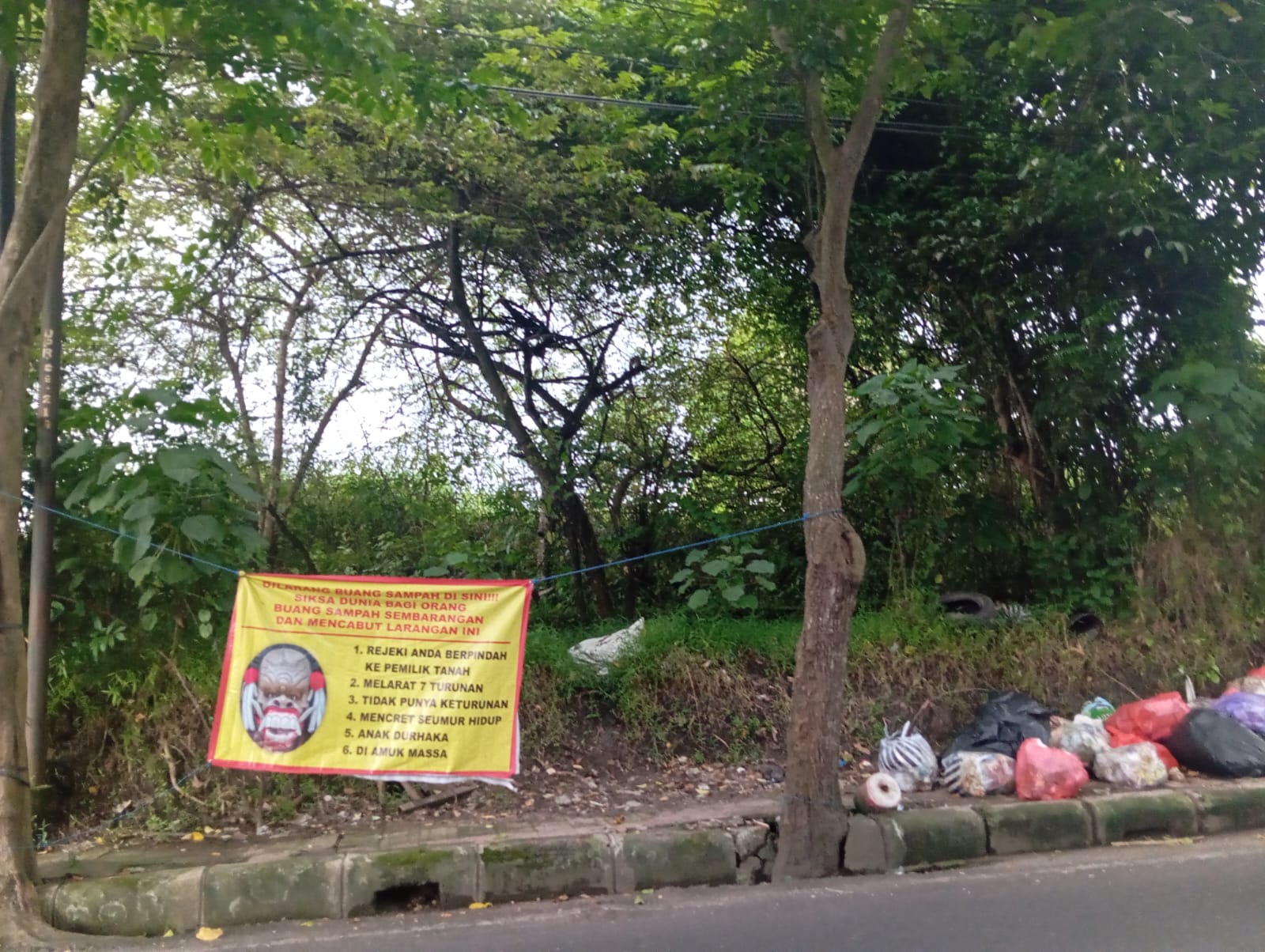 Tumpukan sampah liar tercampur meluber di Jalan Astina Selatan Gianyar, Rabu (19/2) padahal sudah dipasang Spanduk &lsquo;kutukan&rsquo; mencret seumur hidup.