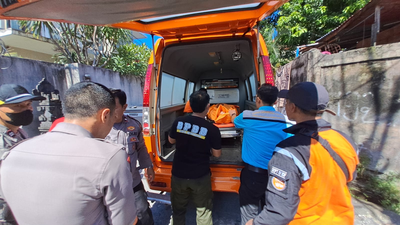 EVAKUASI:  Jenazah Nyoman Suparta yang ditemukan tewas di sumur dievakuasi dengan mobil untuk penyelidikan lebih lanjut.
