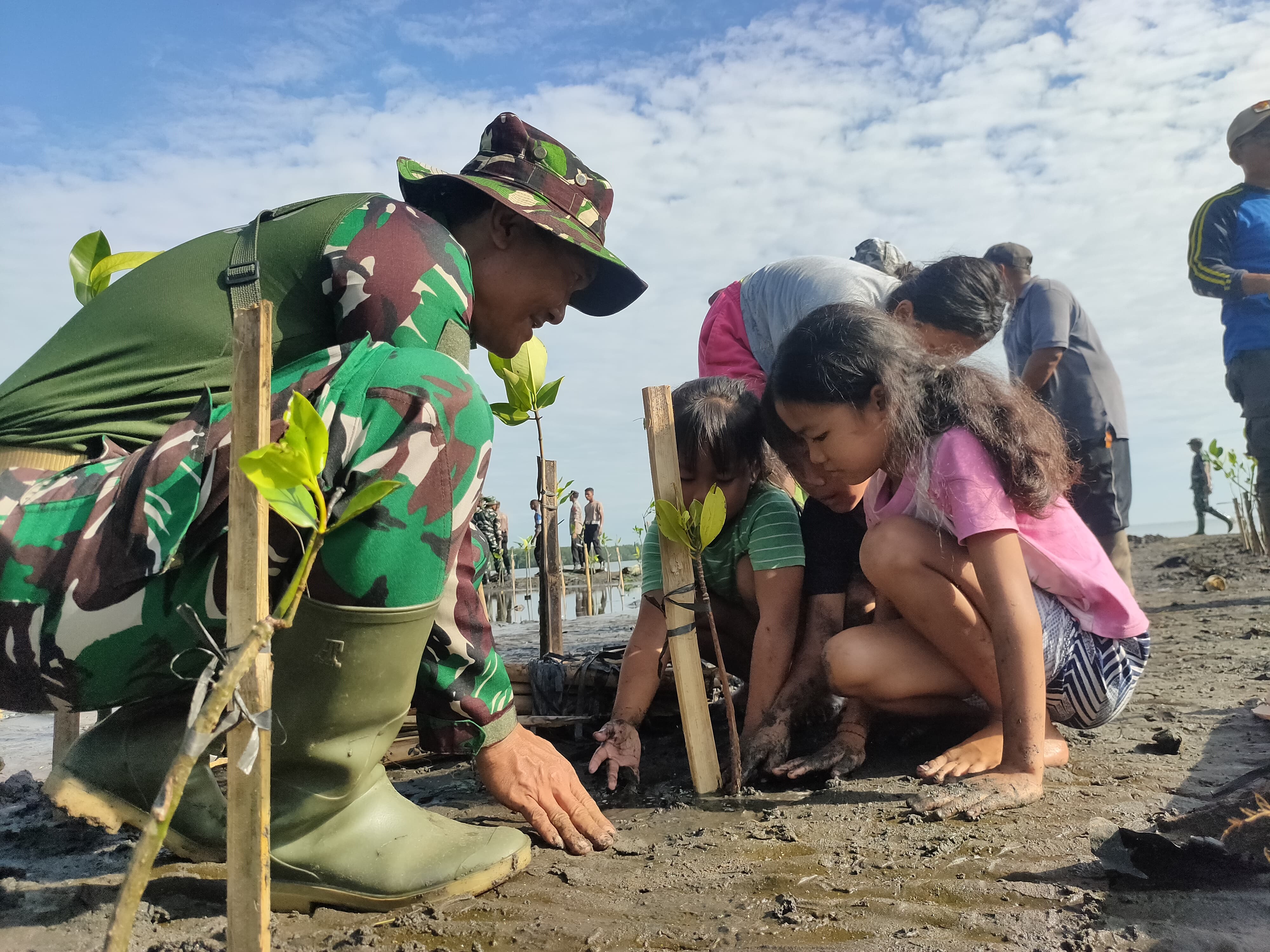 TNI/Polri menanam bakau di Pantai Teluk Terima, Desa Sumberklampok, Buleleng bersama masyarakat.