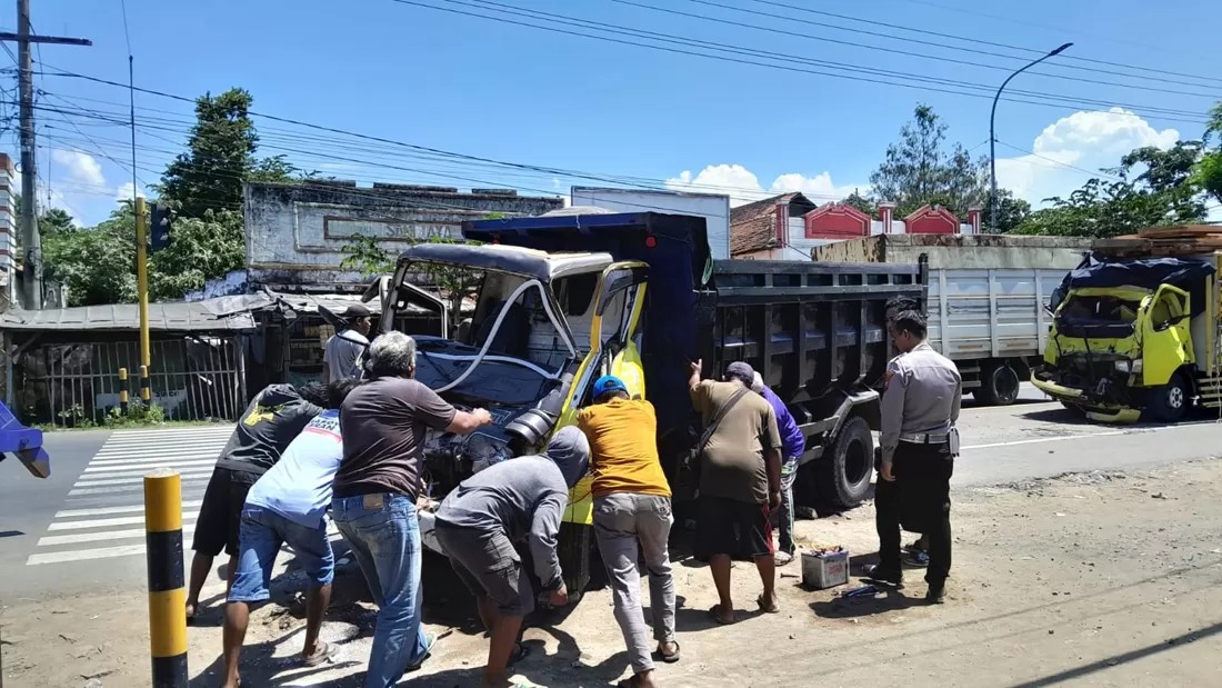 Puluhan warga gotong royong mengeluarkan Sujito, 24, sopir truk yang terjepit kabin di simpang tiga Desa Asembagus, Kecamatan Asembagus, Senin (3/3/2025).