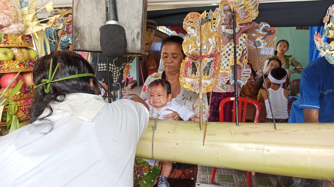 Prosesi melukat wayang oleh Jro Dalang untuk bayi tiga bulan