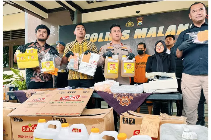 Polisi menunjukkan barang bukti pemalsuan minyak goreng merek Sunco menggunakan minyak goreng curah yang dilakukan pasangan suami istri di Mapolres Malang. (NAHDIATUL AFFANDIAH/RADAR MALANG)