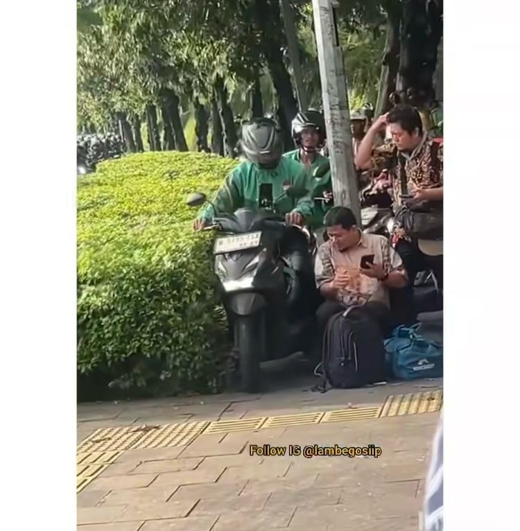 TROTOAR: Seorang ojol terlihat melintas di atas trotoar, sementara seorang bapak sedang duduk di bawah.