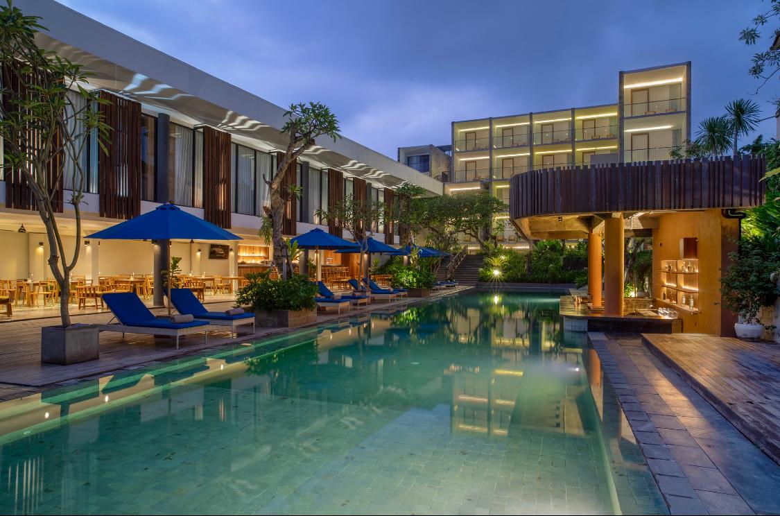 Suasana kolam renang Dialoog Seminyak pada malam hari di kawasan pariwisata bergengsi di Bali.