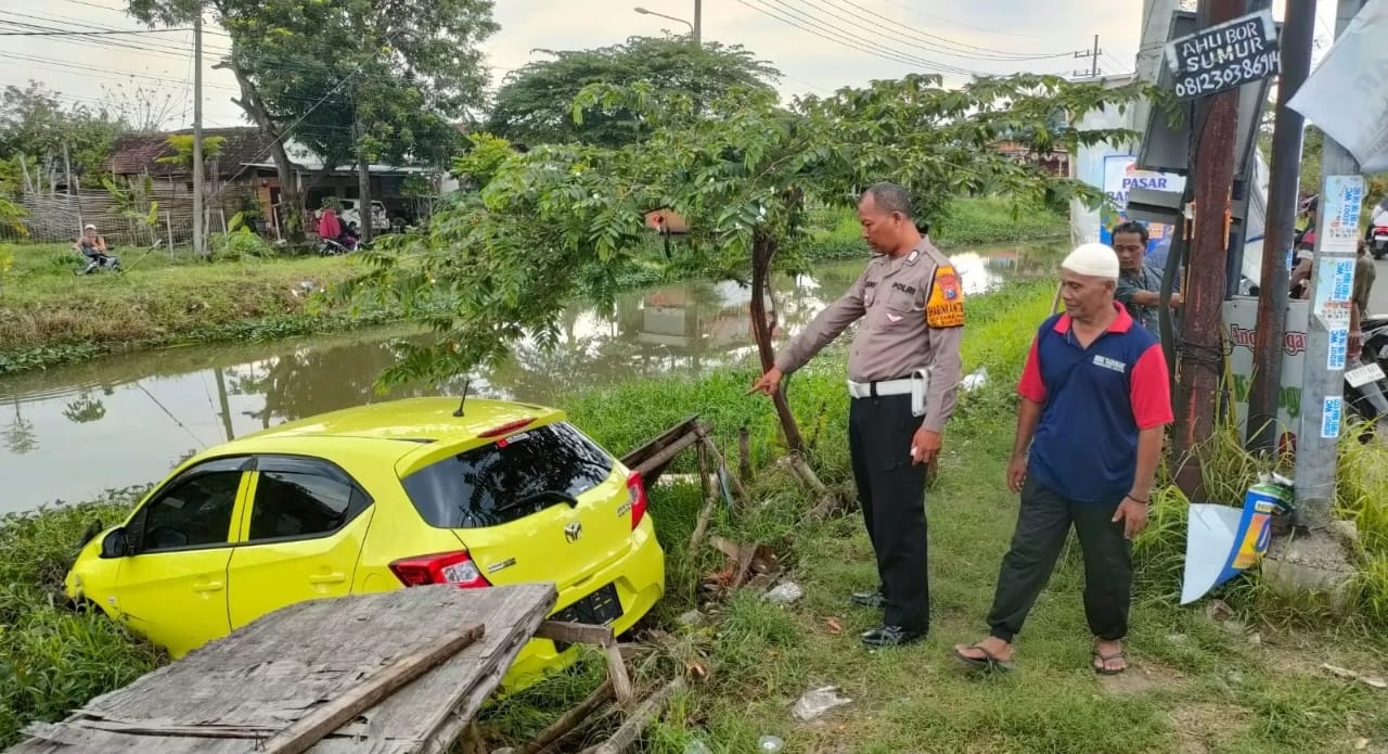 APES : Mobil kuning tercebur ke sungai di Jalan Raya Masanganwetan, Sukodono, Selasa (18/3). (IST/RADAR SIDOARJO)