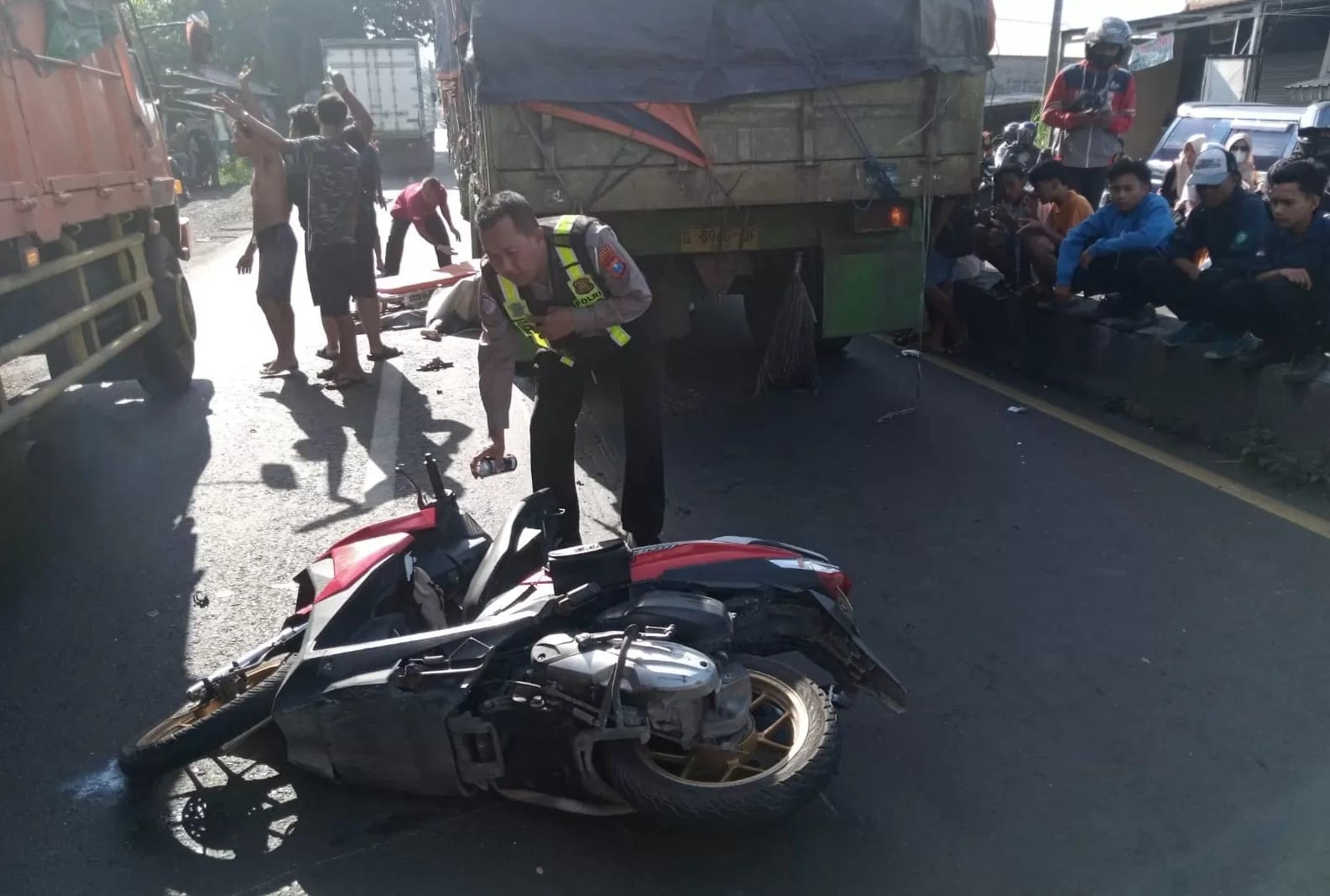 Petugas sedang mengevakuasi korban kecelakaan maut di Jalan Raya Desa Suwaluh, Balongbendo, Sidoarjo, Kamis (20/3/2025).