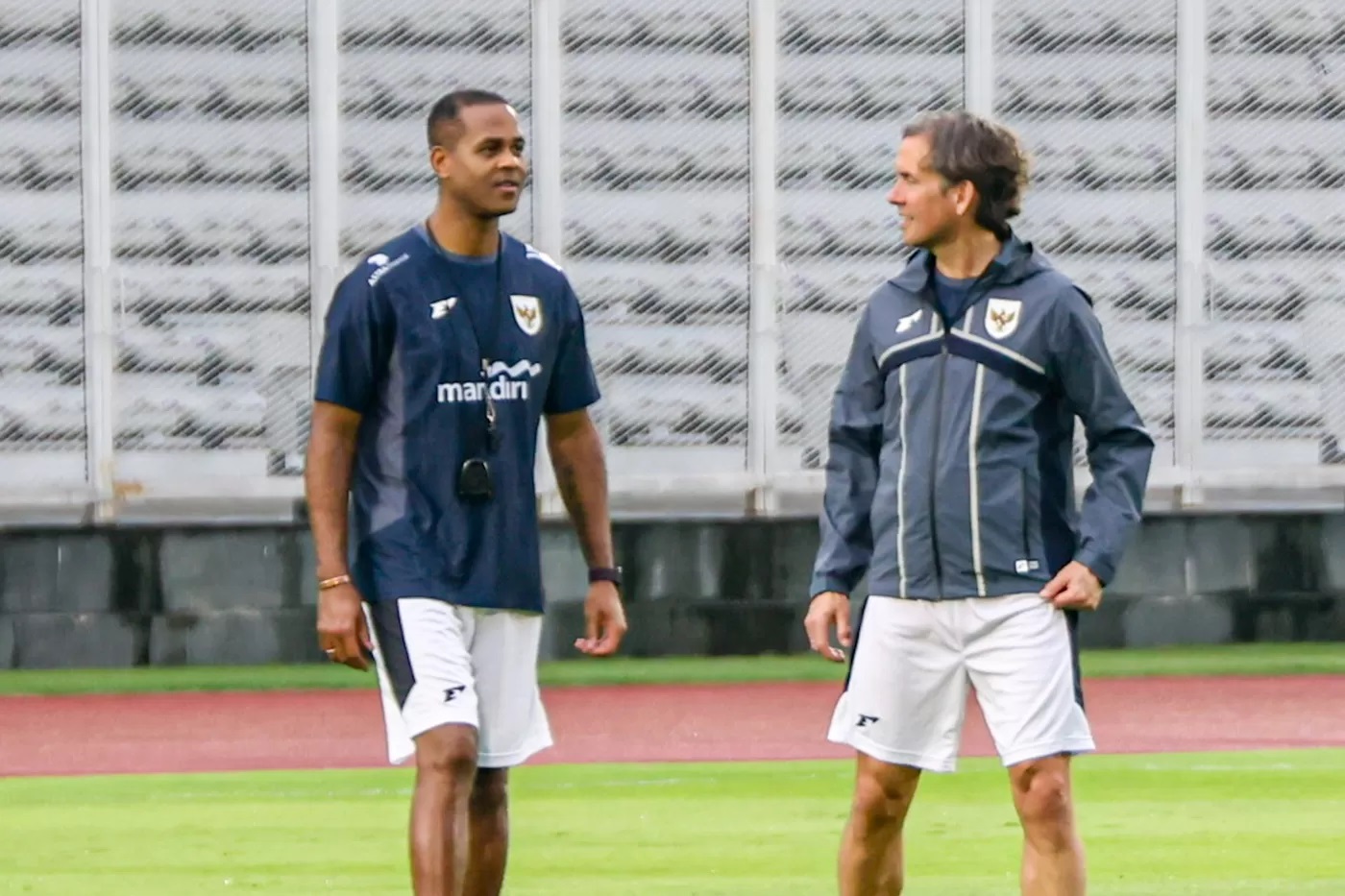Pelatih Timnas Indonesia Patrick Kluivert (kiri) bersama Alex Pastoor (kanan) memperhatikan anak asuhnya berlatih jelang pertandingan Kualifikasi Piala Dunia 2026 di Stadion Madya, komplek GBK.