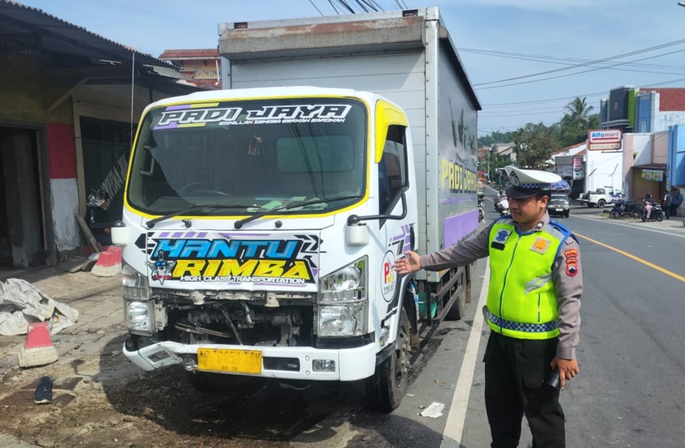 Anggota Satlantas Polresta Cilacap menunjukkan truk boks yang terlibat kecelakaan beruntun di Jalan Raya Karangpucung.