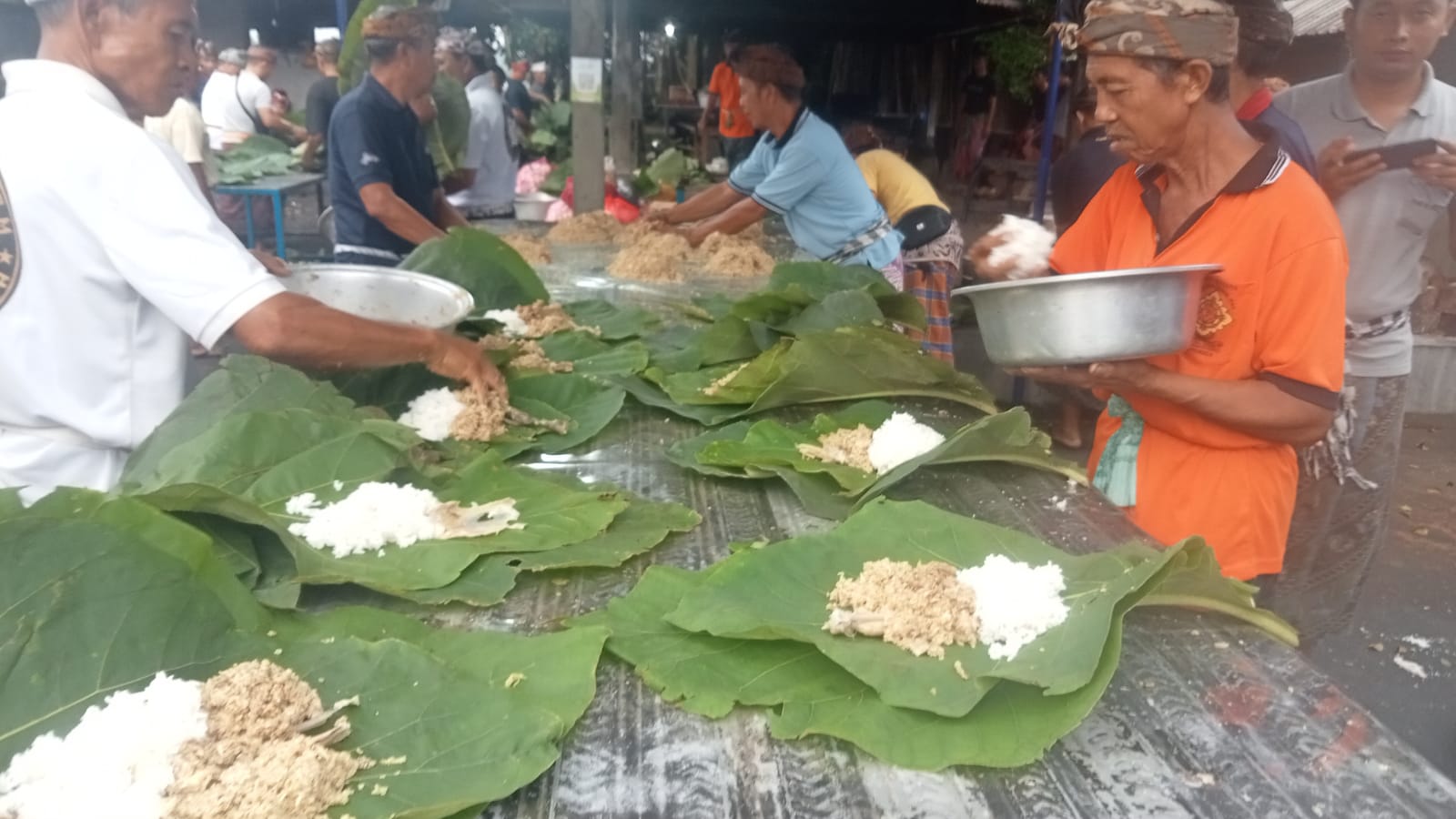 Prosesi membungkus Lawar dan nasi dengan daun jati di Desa Adat Bengkala