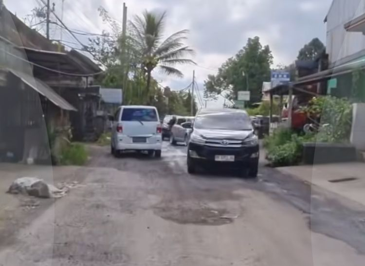 Seorang pengendara mengeluhkan jalan menuju Pura Besakih yang masih rusak parah
