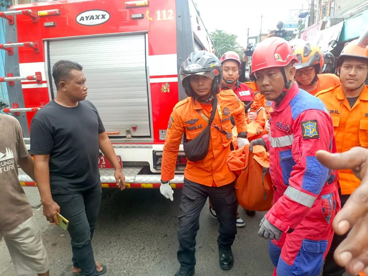 DIEVAKUASI : Petugas gabungan membawa mayat korban tertimpa tembok rumah, Achmad Farid Solihuddin menuju ambulans untuk dibawa ke RSUD dr Soeotomo Surabaya.