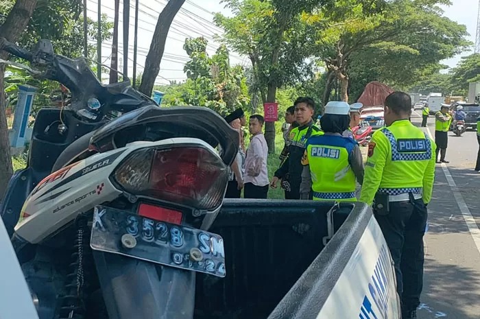 DIEVAKUASI: Petugas melakukan evakuasi sepeda motor pasutri dan anak yang terlindas truk.