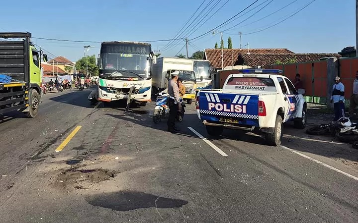 Petugas melakukan pengaturan arus lalu lintas usai motor trail Honda CRF tabrakan dengan Bus Jawa Indah di Tongas, Probolinggo, Selasa pagi (8/4/2025).