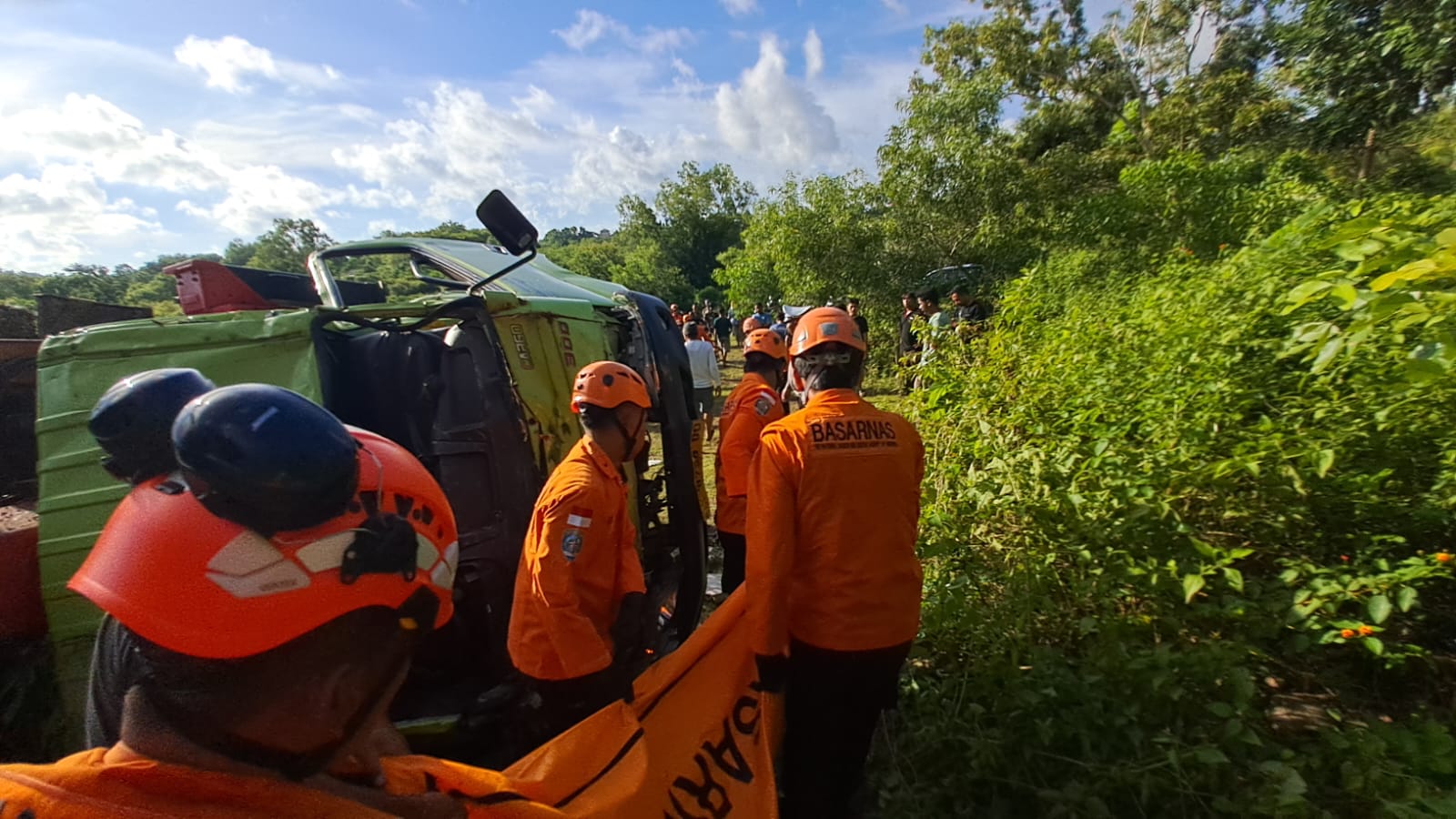 EVAKUASI: Petugas mengevakuasi jenazah sopir truk yang terguling.