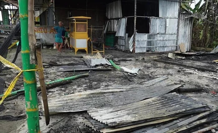 TERBAKAR: Sulis (34) pemilik warung soto di Desa Bandung Kecamatan Diwek saat di warungnya usai ludes terbakar.