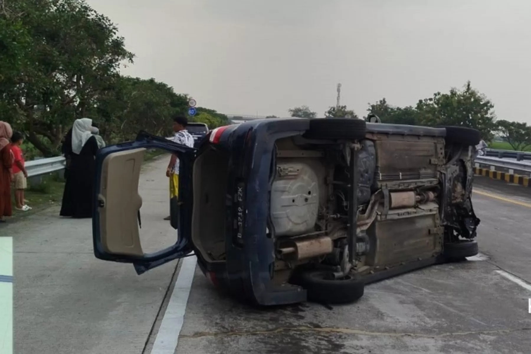 TERGULING: Kondisi mobil Nissan Grand Livina Bernopol B 1719 FZK terguling di Tol Jombang kemarin (14/4).