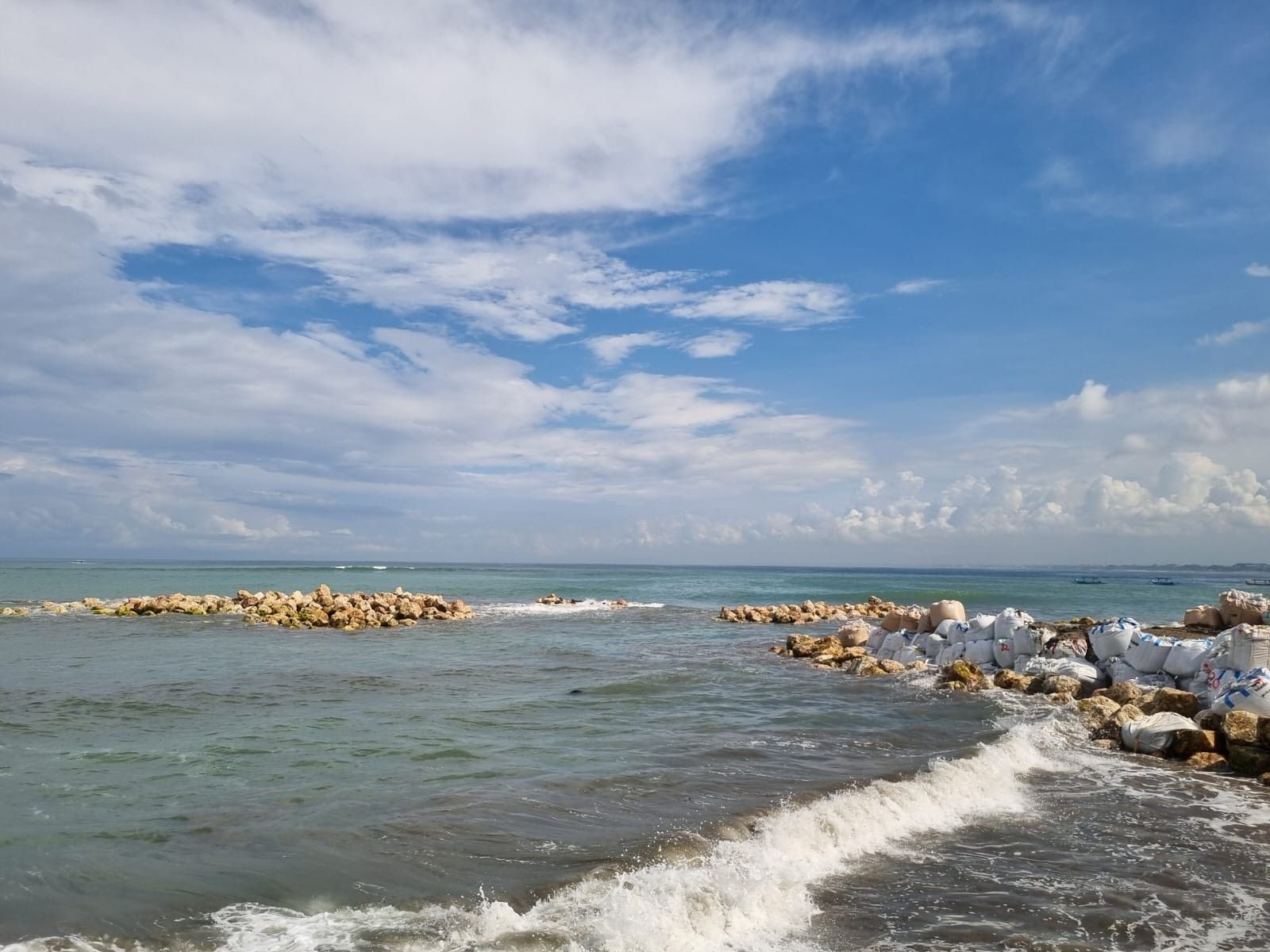 Penataan material breakwater di tengah laut depan Discovery Mall, Kuta, Senin (14/4/2025).