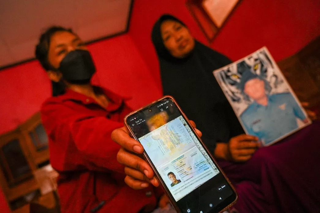 FOTO KORBAN: Keluarga memegang foto paspor dan foto Rizal yang jadi korban di Kamboja, Selasa (15/4).