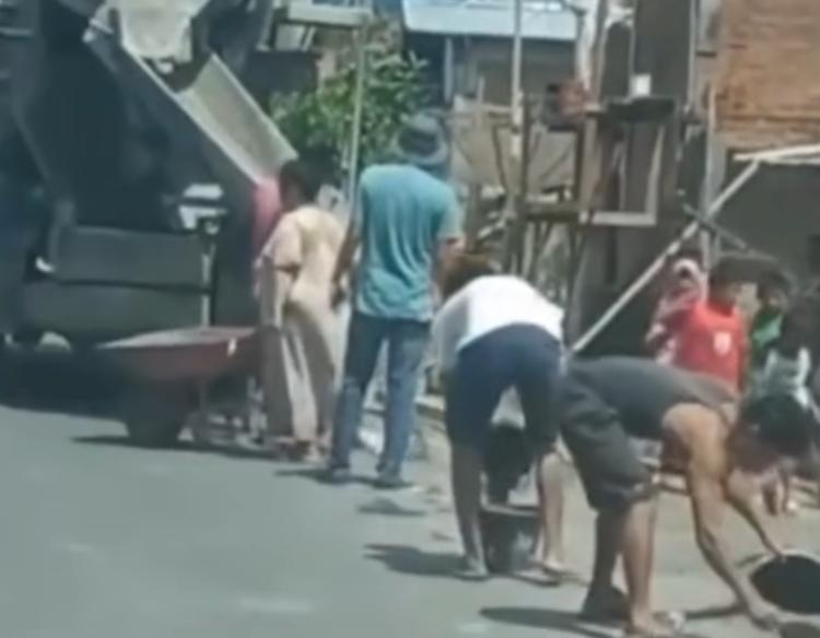 Sejumlah warga terlihat kompak mengambil sejumlah semen yang tumpah dari truk cor