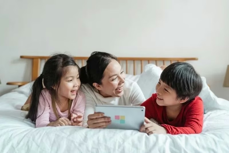 Ilustrasi orang tua mendampingi anak menggunakan gawai.