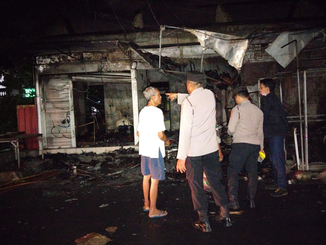 DIJAGA: Petugas menjaga area bangunan ruko dan kos yang tampak ludes setelah diamuk si jago merah.