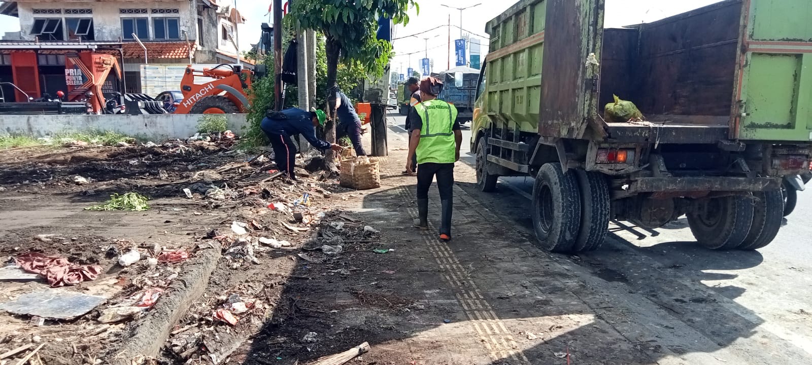 DIBERSIHKAN: Proses pembersihan sampah liar di lahan kosong yang berlokasi di kawasan Jalan Bypass I Gusti Ngurah Rai, Jimbaran, Kuta Selatan, Minggu (27/4).