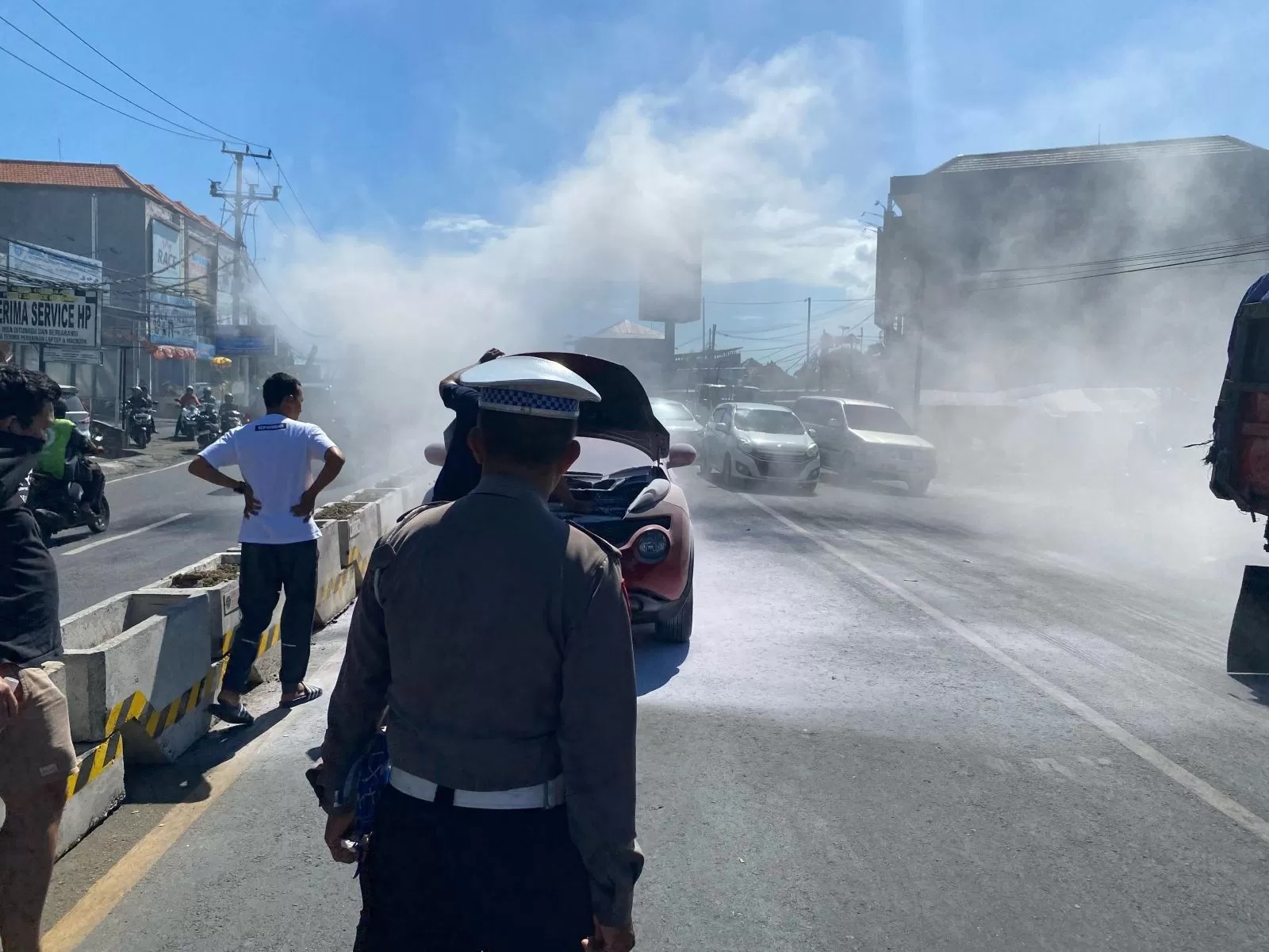 TERBAKAR: Mobil Nissan Juke terbakar hingga membuat kemacetan panjang di Jalan Teuku Umar Barat Denpasar, Minggu, 27 April 2025