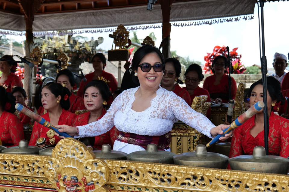 Ny. Rai Wahyuni Sanjaya saat ngaturang ayah menabuh dan megambel di Pura Agung Besakih