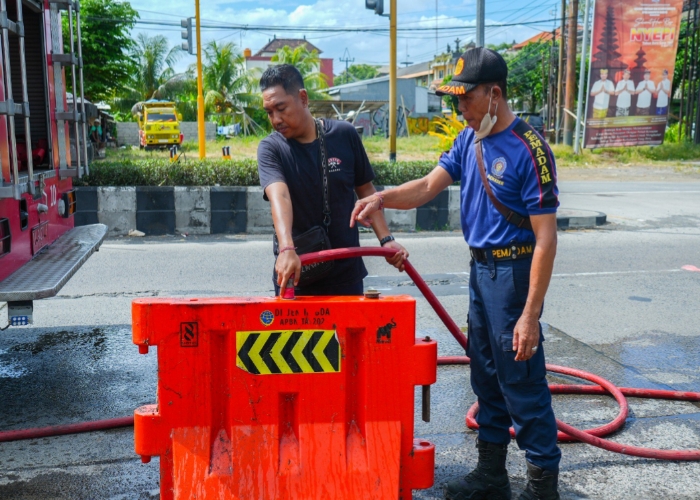 PEMASANGAN: Proses pemasangan water barier di Jalan Terminal Mengwi, dan Jalan Jaksa Agung R Soeprapto, Selasa (6/5).