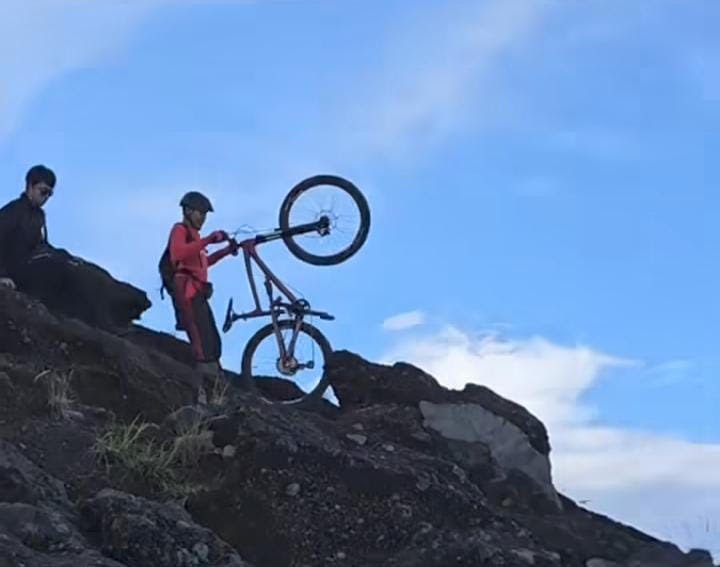 SEPEDA: Seorang pendaki membawa sepeda ke puncak Gunung Agung.