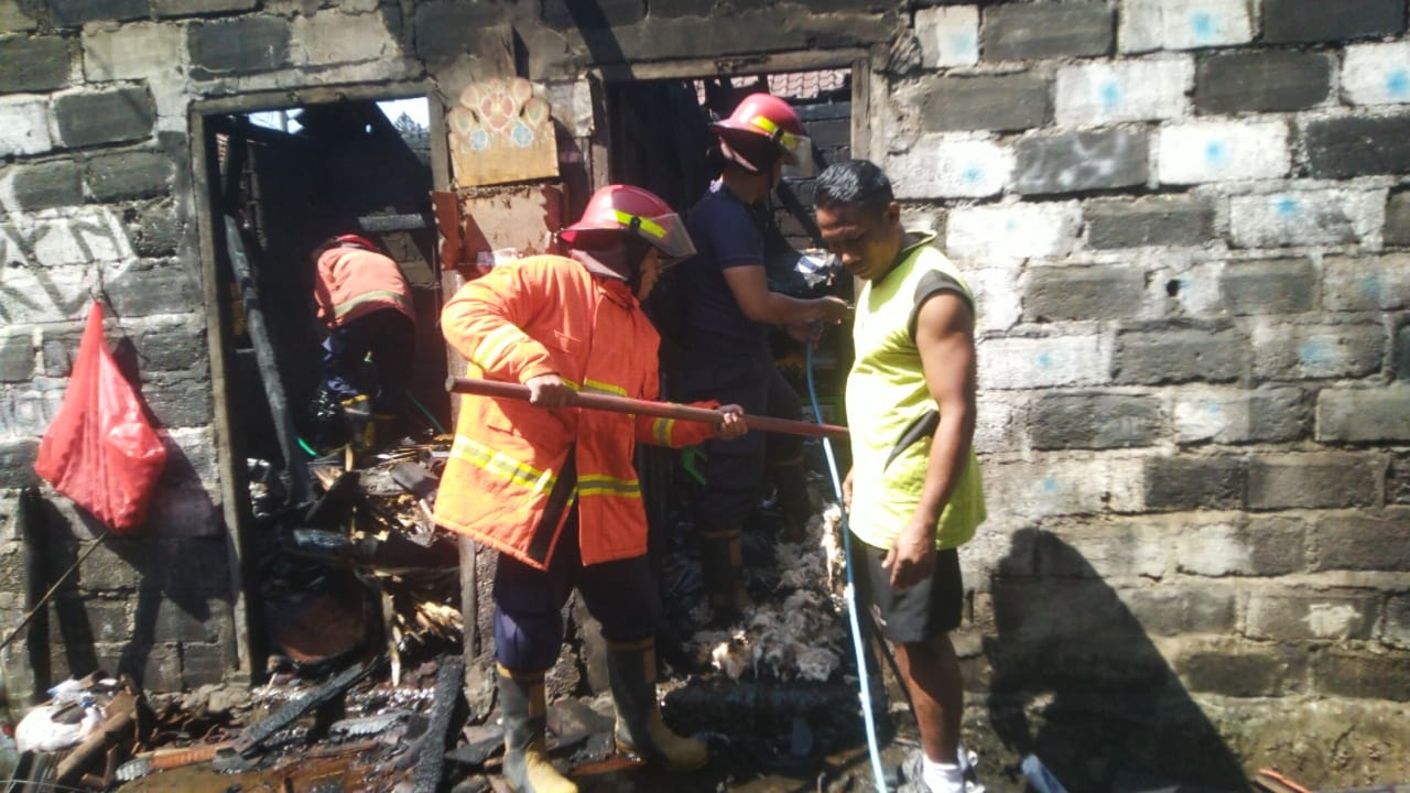DAMKAR: Petugas Damkar Karangasem melakukan pendinginan api yang membakar kamar tidur dan dapur.